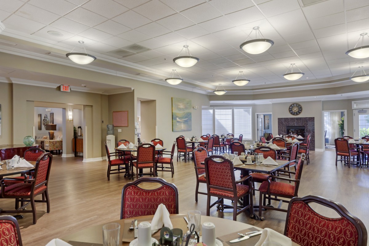 A well-lit dining area with tables and chairs arranged for service.