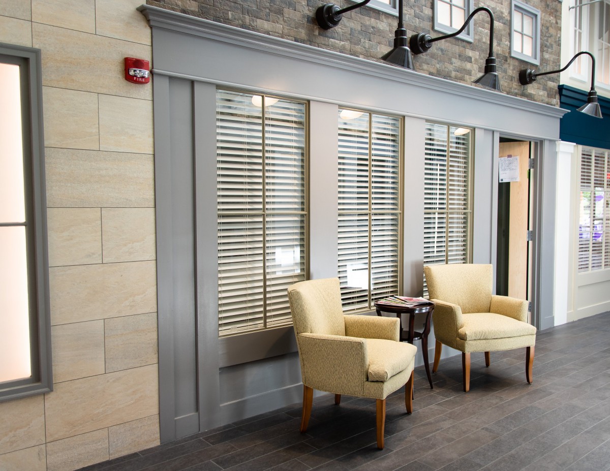 A cozy waiting area with two armchairs and a small table in front of large windows.