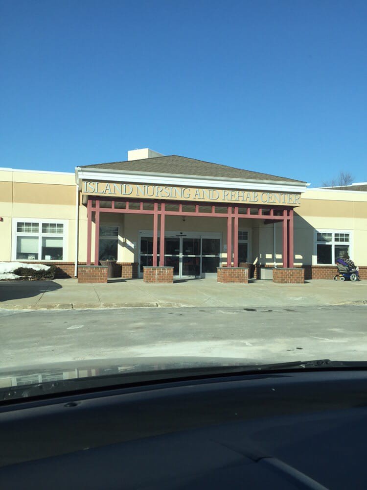 A storefront building on a sunny day with an empty parking lot in front.