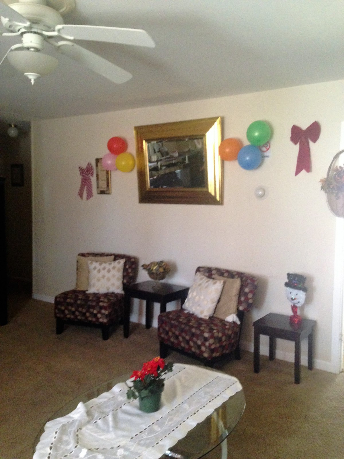 A cozy living room decorated with colorful balloons and a large mirror on the wall.