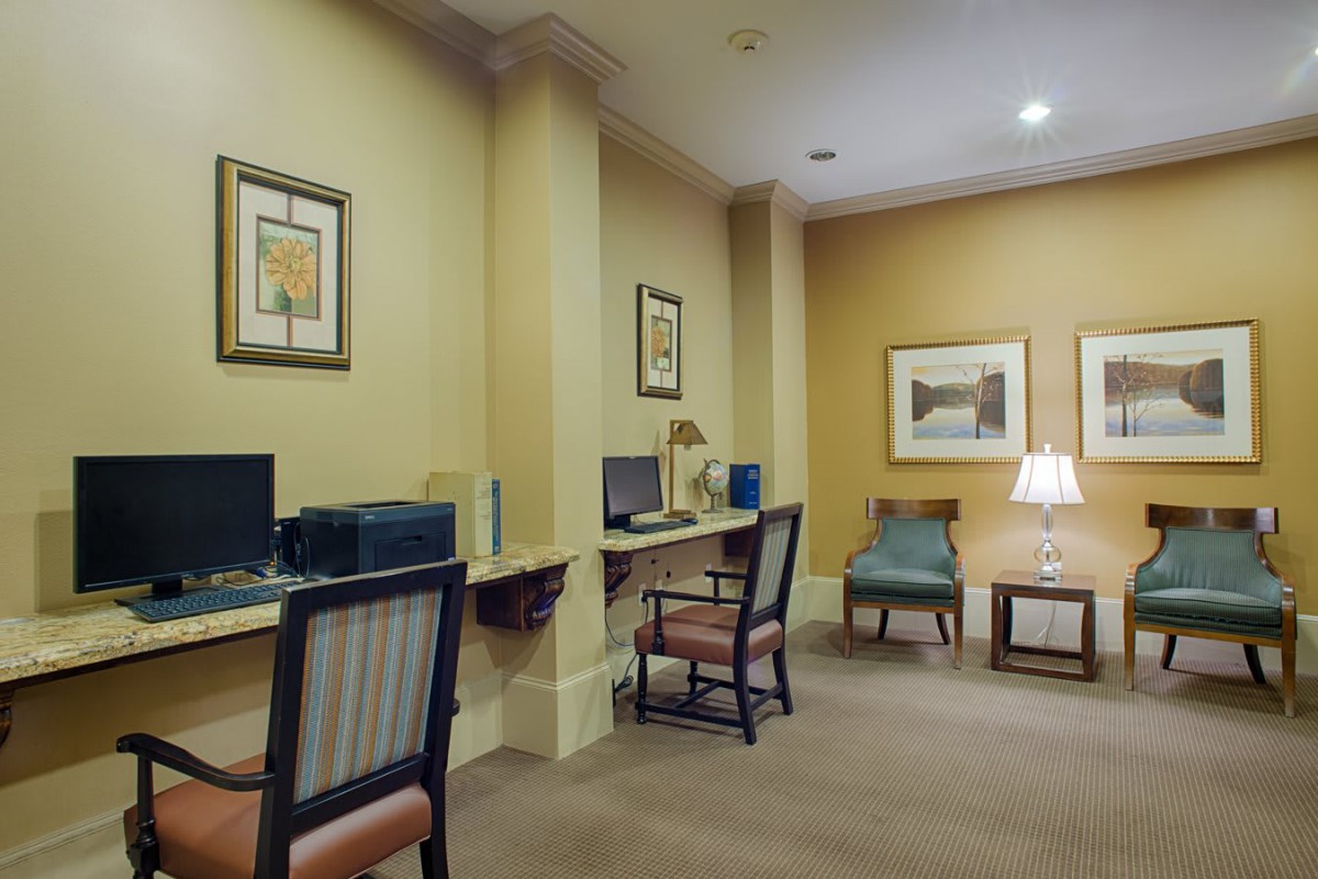 A quiet office space with computers and seating, featuring decorative artwork on the walls.