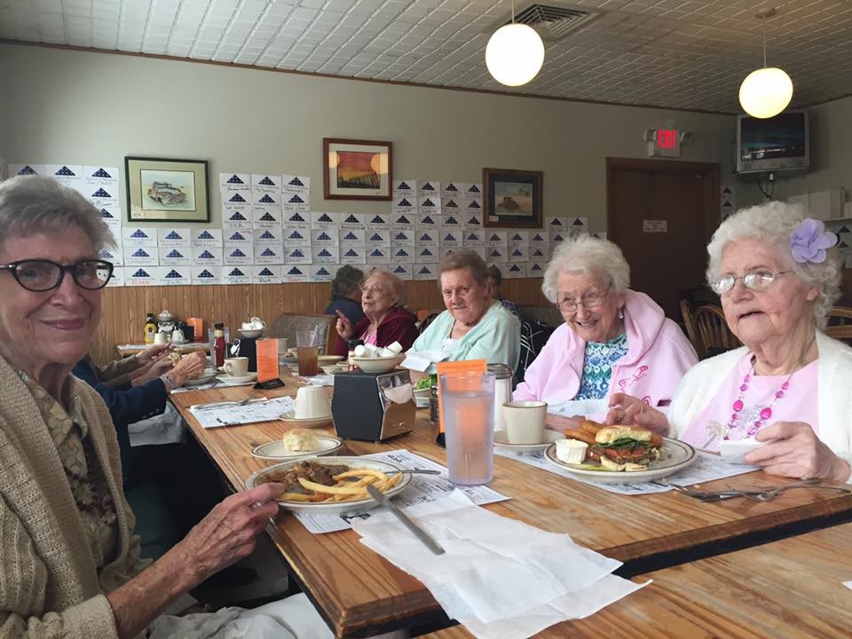 A group of seniors enjoying a meal together at a restaurant.