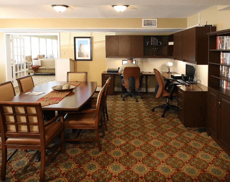 Spacious office interior with desks, chairs, and a patterned carpet.