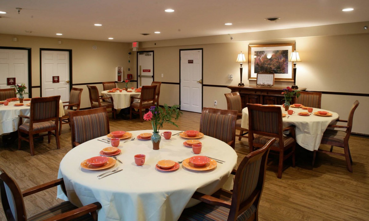 A cozy dining area with elegantly set tables and warm lighting.
