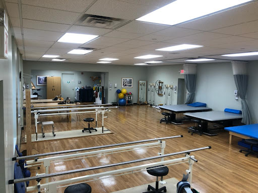 A spacious physical therapy room equipped with various rehabilitation tools and exercise equipment.