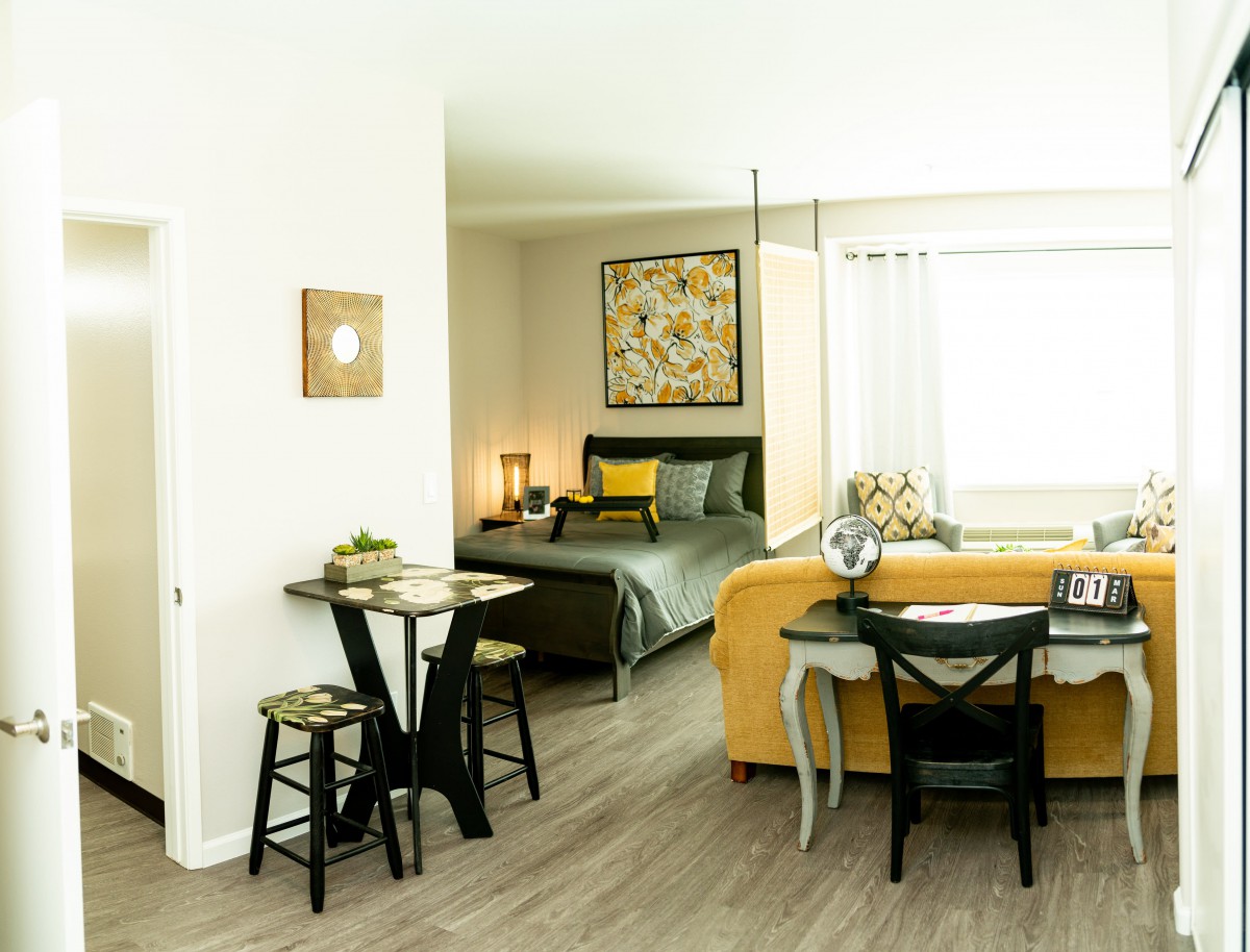 A modern studio apartment featuring a cozy bedroom, stylish living area, and compact dining space.