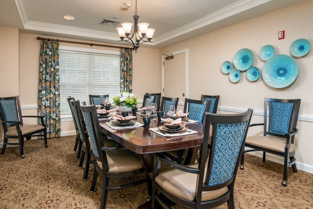 A beautifully decorated dining room with a large table and upholstered chairs.
