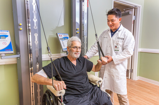 A healthcare professional assists a patient in a rehabilitation setting, showcasing the importance of support in physical therapy.