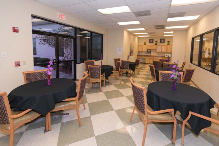 A small dining area with decorated tables and chairs placed on a checkered floor.