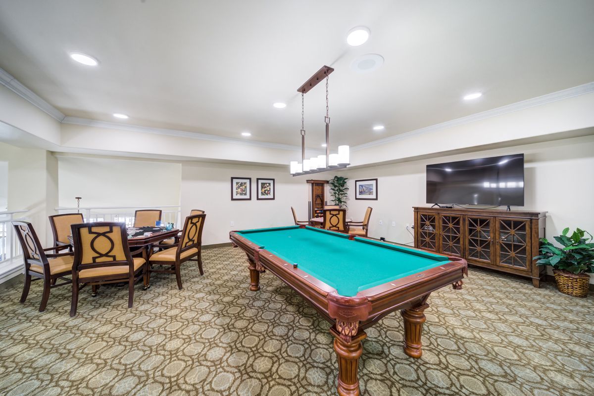 A well-furnished game room featuring a pool table and seating area.