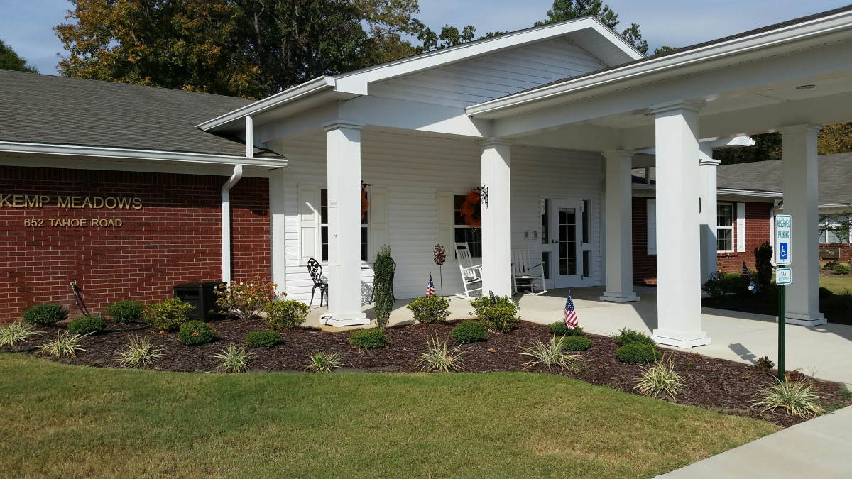 A modern house with a covered porch and well-maintained garden.