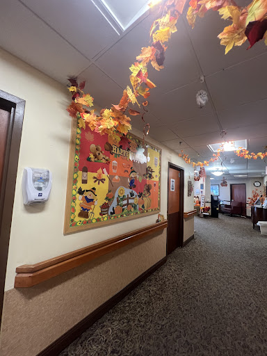 A cozy hallway adorned with autumn decorations, featuring colorful leaves and art on the walls.