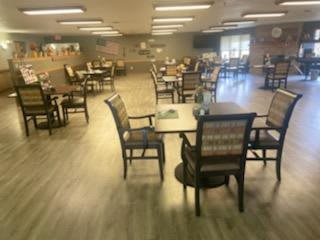 An empty dining area with tables and chairs arranged in a spacious room.