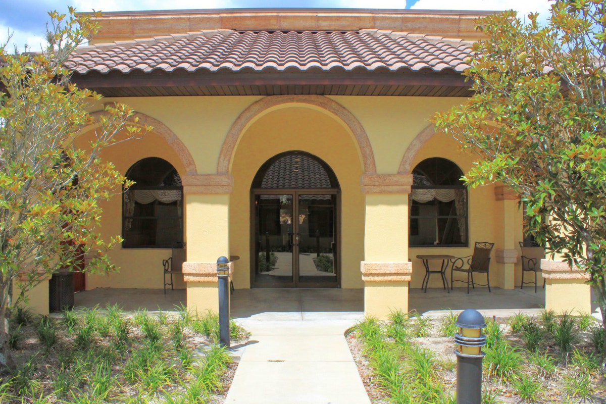A Mediterranean-style building with arches and surrounding landscaping.