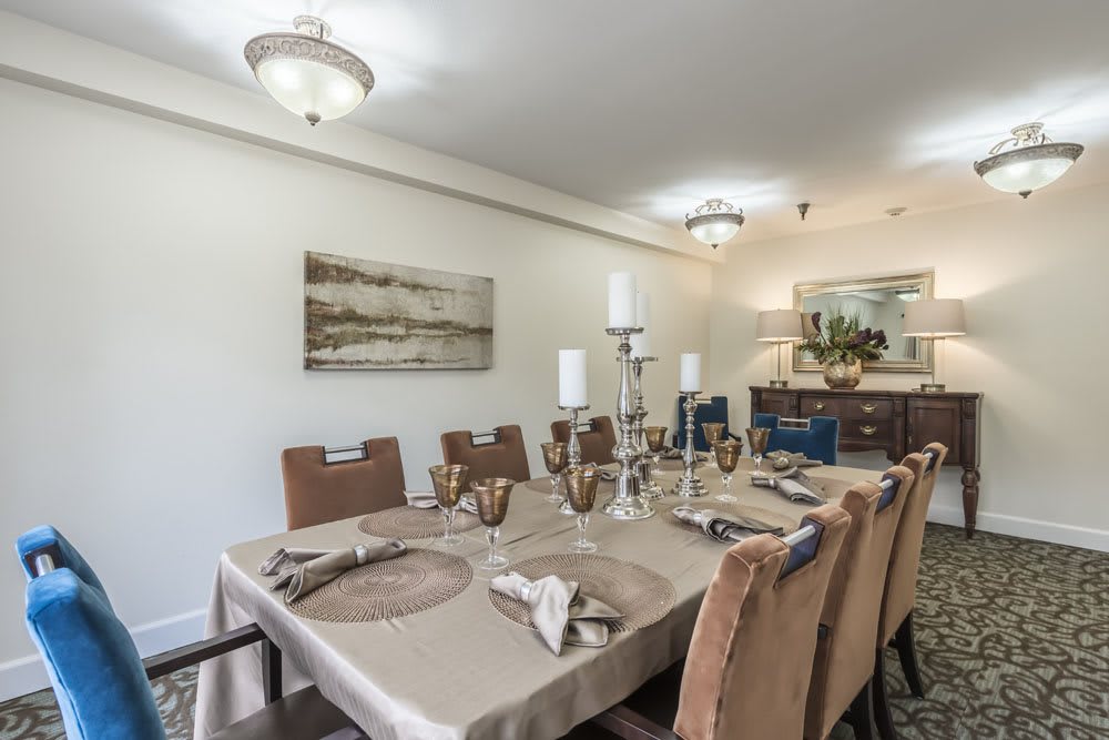 A well-appointed dining room featuring a neatly set table with candles and decorative accents.