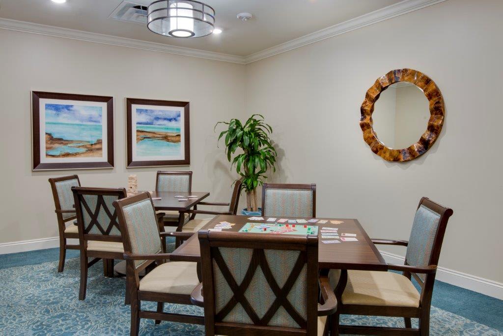 A cozy dining area with a wooden table, cushioned chairs, abstract artwork, and a decorative mirror.
