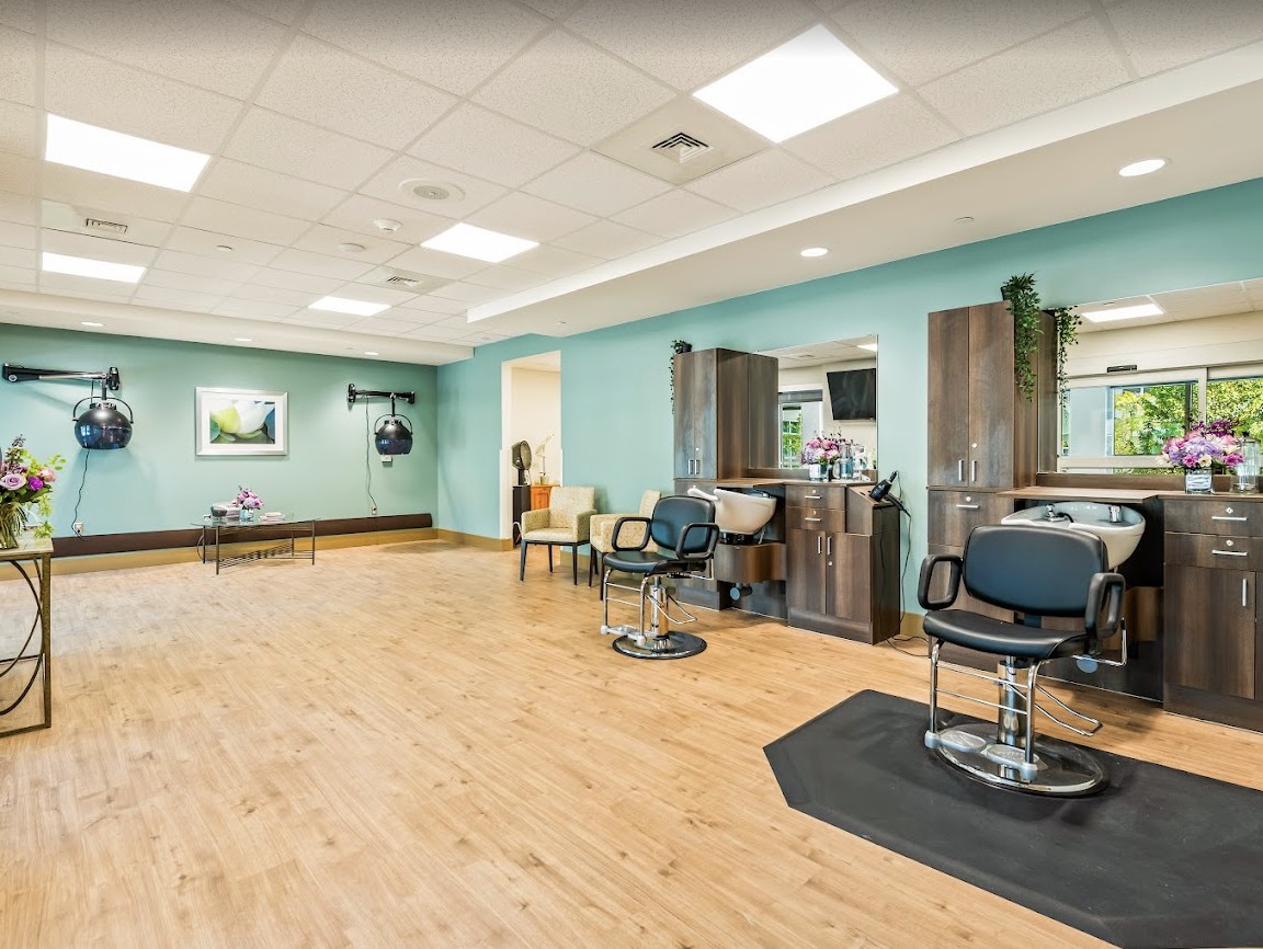 A modern hair salon interior with barber chairs and mirrors.