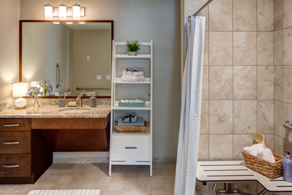 Modern bathroom with a standing shelf and a tiled shower area.