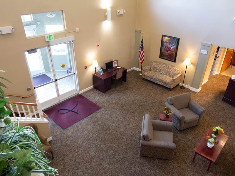 An aerial view of a lobby with seating arrangements, a desk, and decor.