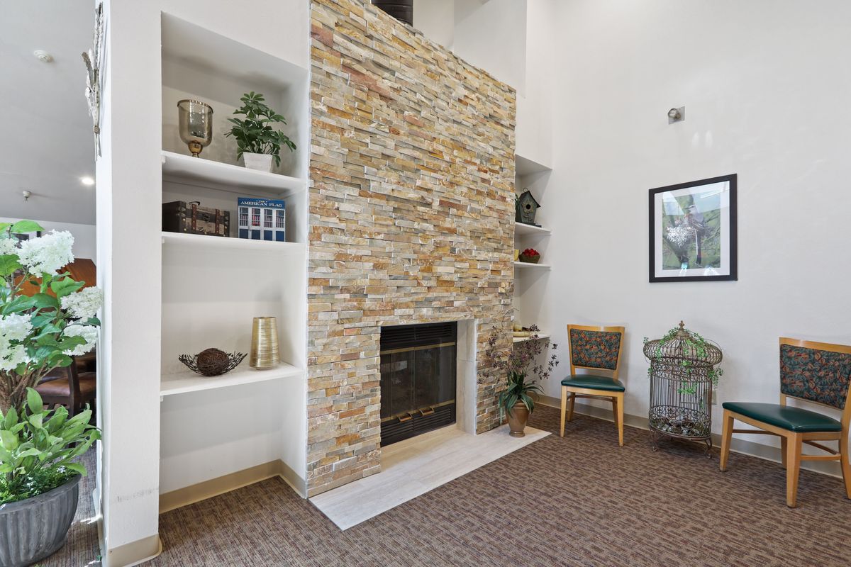 A cozy living room with a stone fireplace and built-in shelves.