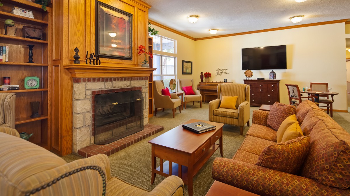 A cozy living room with a fireplace, comfortable seating, and a television, creating a warm and inviting atmosphere.