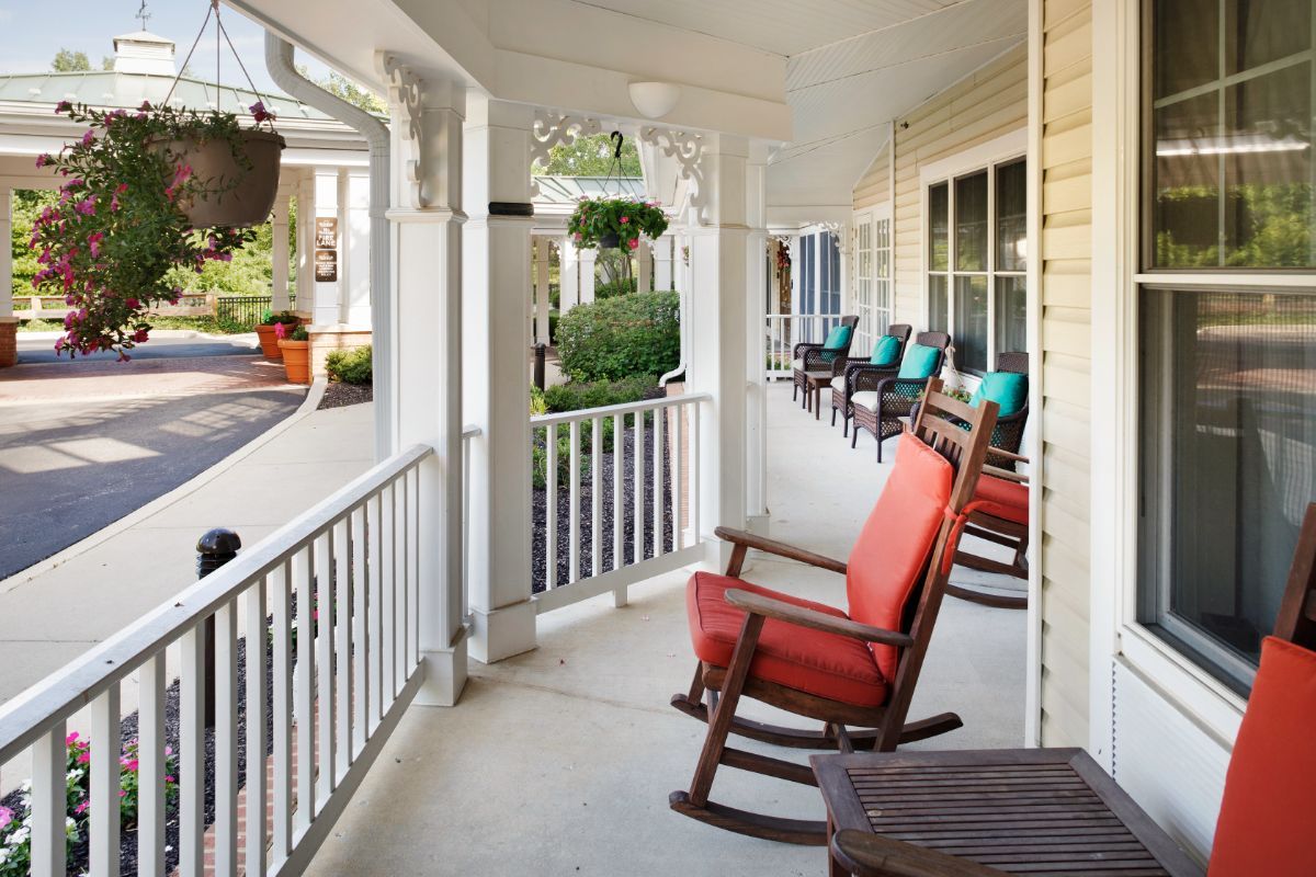 A cozy porch featuring several rocking chairs, perfect for relaxation and enjoying the outdoor view.