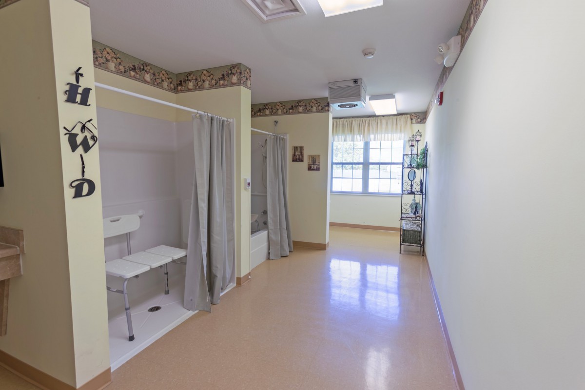 A clean and bright hallway in a medical facility with curtained areas for patient privacy.