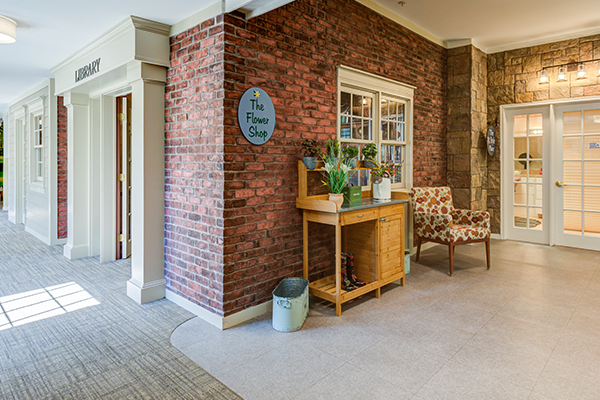 A cozy interior space featuring a brick wall, decorative items on a wooden table, and seating area.