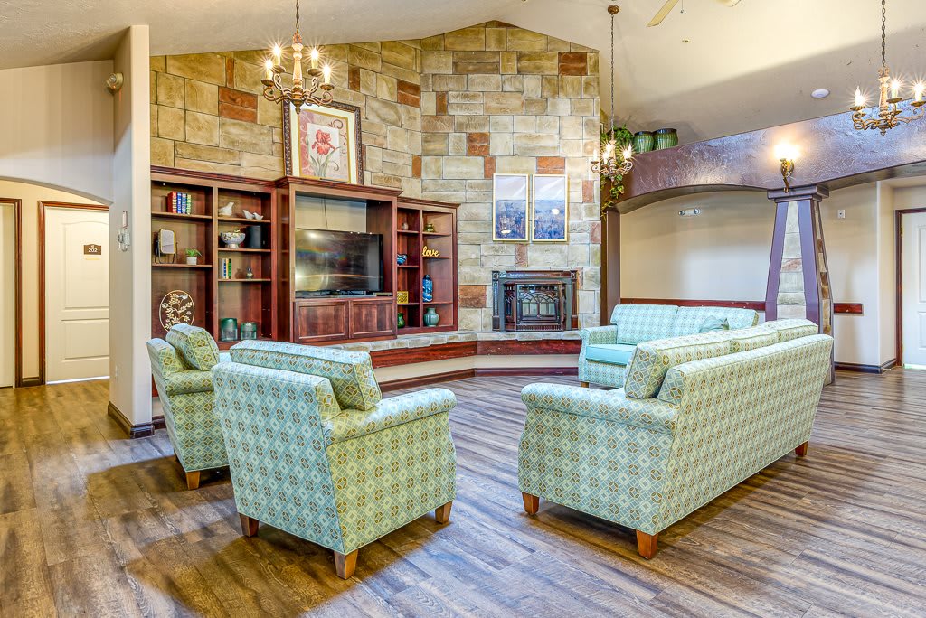 A cozy lounge area with armchairs, a fireplace, and bookshelves.