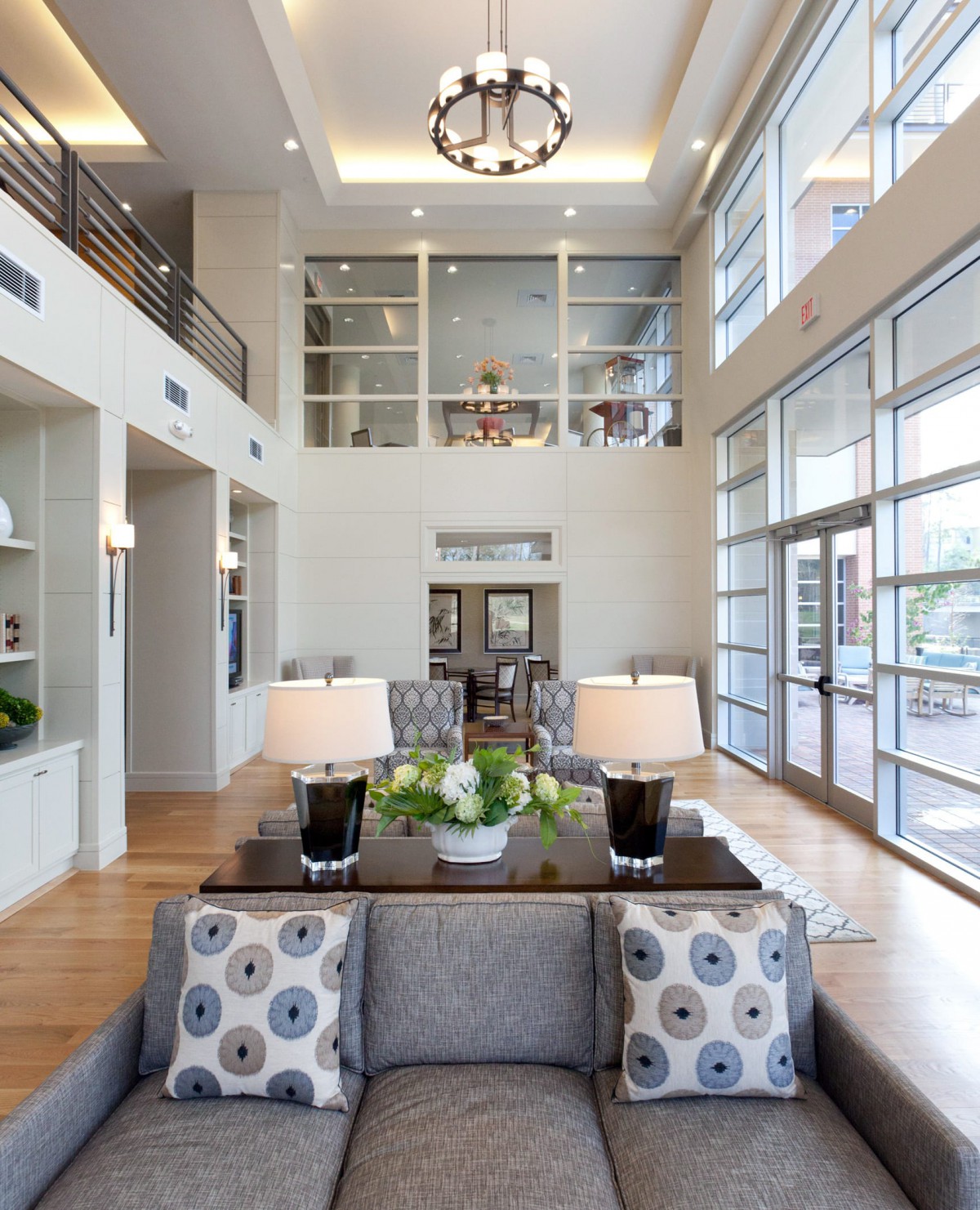 A modern lobby area with tall ceilings, large windows, and stylish furniture.