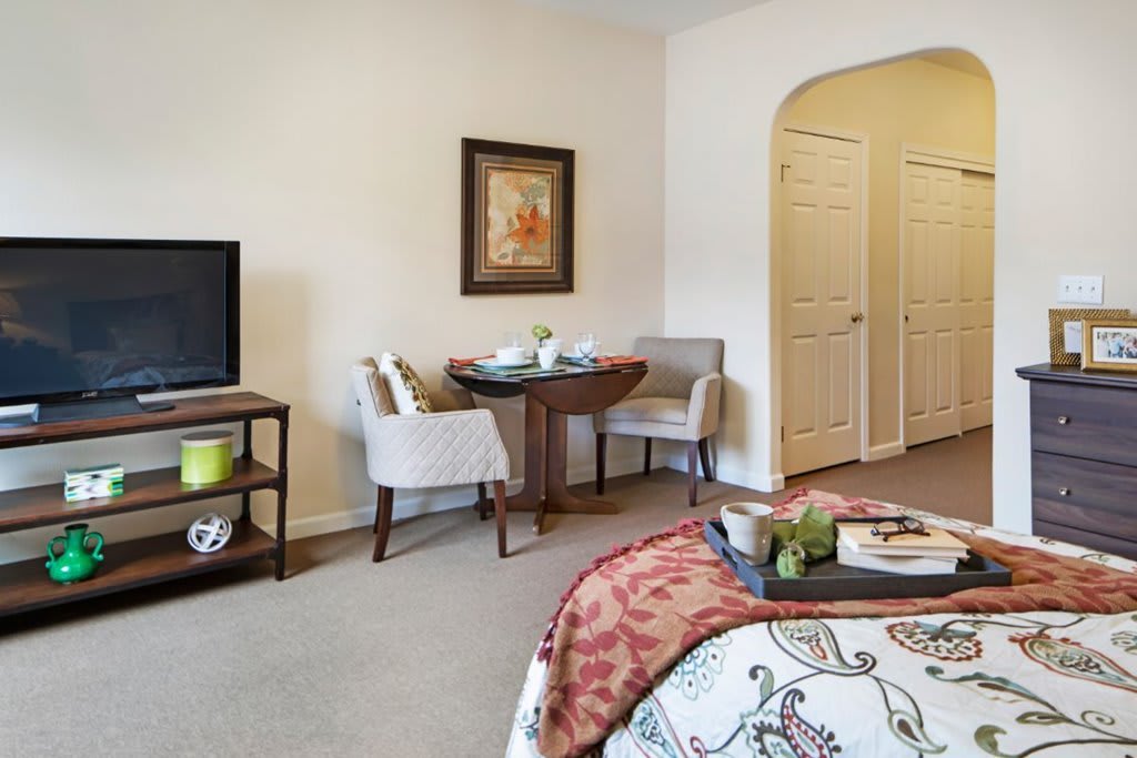 A cozy bedroom with a small dining area and modern decor.