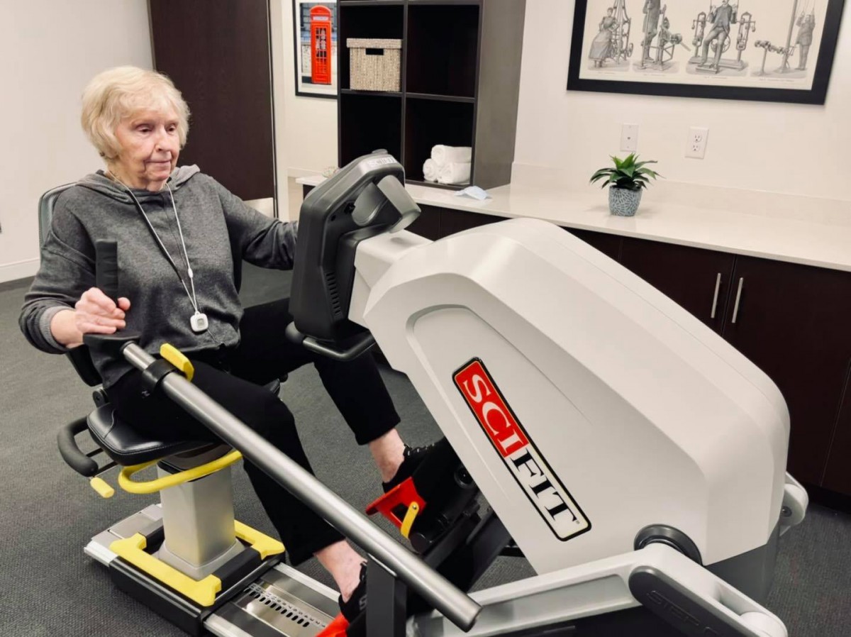 A person using a Scifit exercise machine indoors, focusing on fitness and rehabilitation.