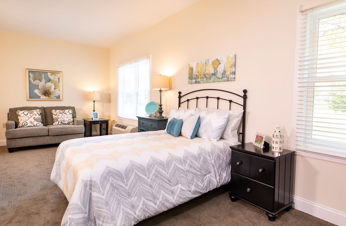 A cozy bedroom with a neatly made bed, nightstands, and decorative lamps.