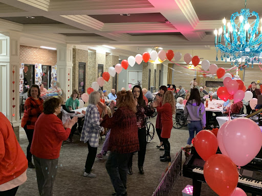 A lively gathering filled with joy and dancing, decorated with red and white balloons.