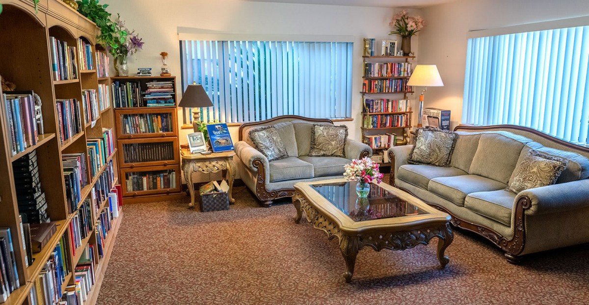 A cozy living room with classic furniture and a well-stocked bookshelf.