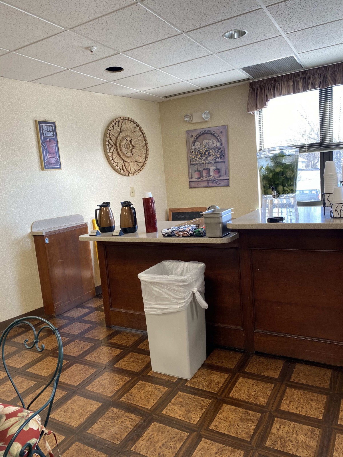 A cozy reception area with a coffee station and wall decorations.