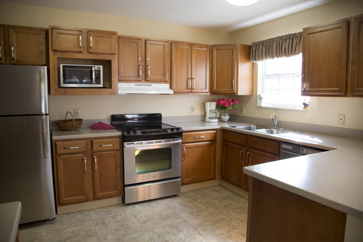 A spacious kitchen with wooden cabinets, modern appliances, and ample natural light.