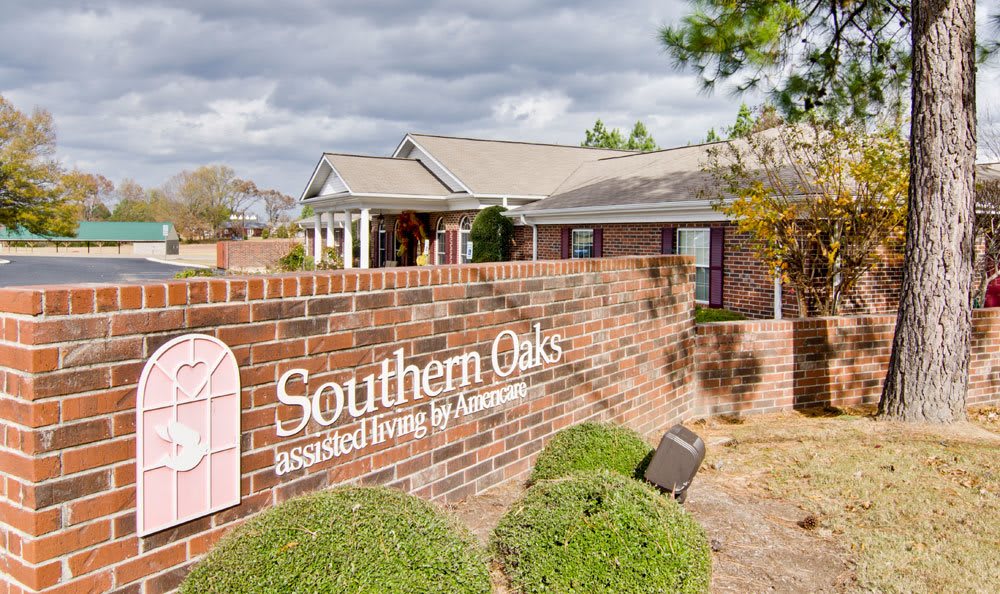Entrance view of Southern Oaks Assisted Living with a prominent brick sign and surrounding greenery.