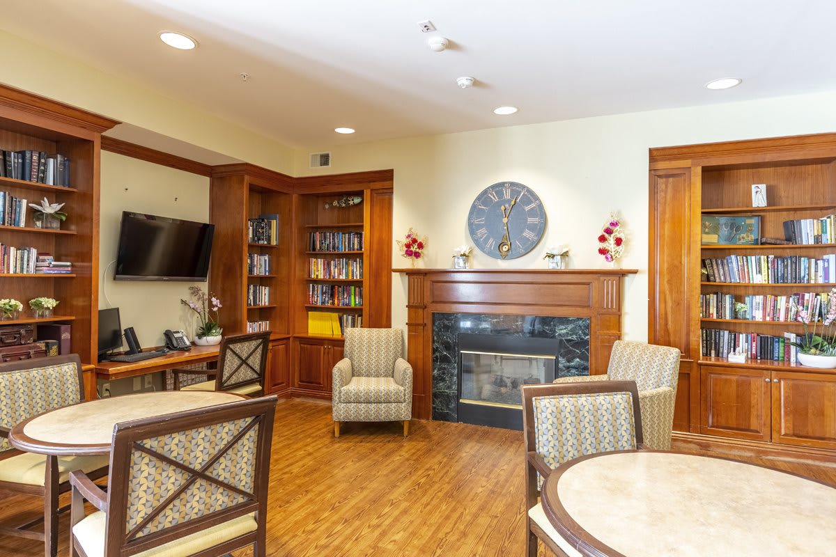 A cozy living room with a fireplace, bookshelves, and comfortable seating.