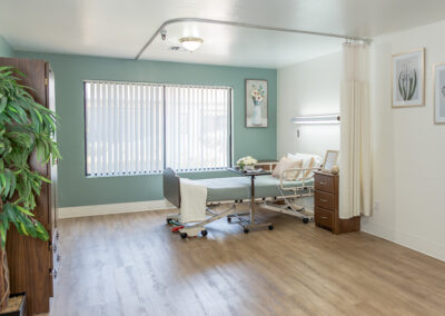 A serene and neatly arranged hospital patient room with natural light filtering through the windows.