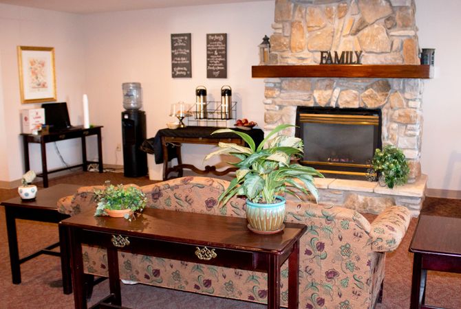 A cozy living room with a fireplace, plants, and inviting decor.