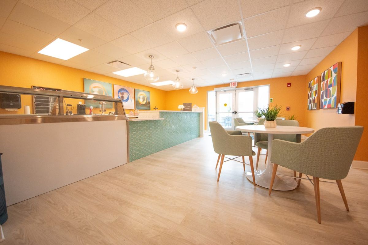 A modern cafe interior with bright colors and a welcoming seating area.