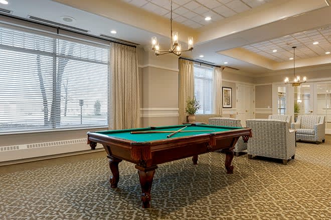 A well-appointed living room featuring a billiard table and elegant decor.