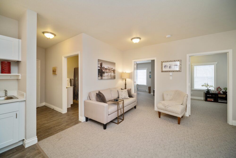 A cozy living room with a sofa, armchair, and stylish decor.