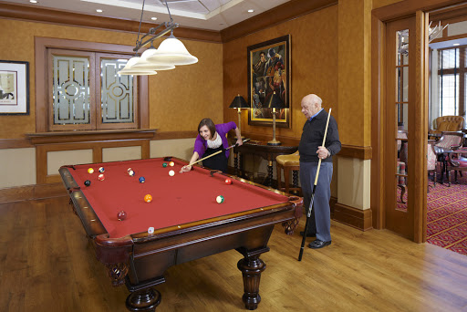 Two individuals enjoying a game of pool in a stylishly designed room.