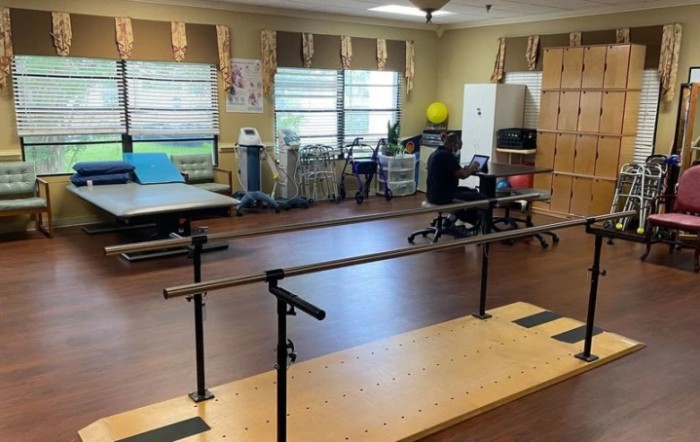 A physical therapy room equipped with parallel bars and exercise equipment.