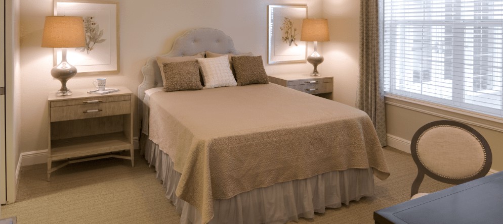 A cozy bedroom with a neatly made bed and ambient lighting.