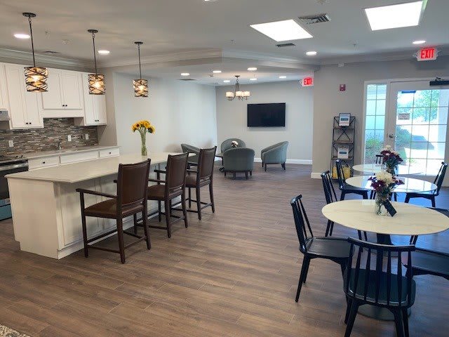 A modern open-plan living and kitchen area with seating and a wall-mounted television.
