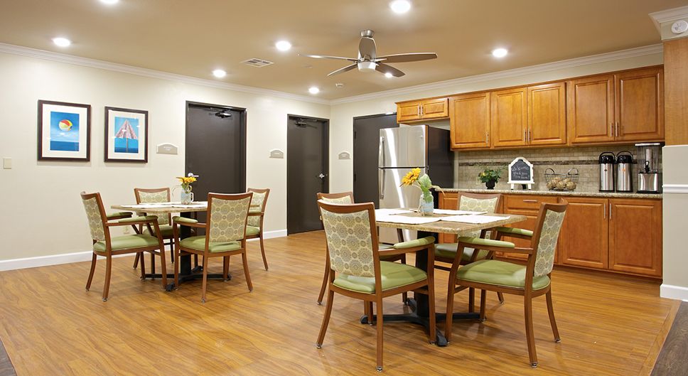 A modern kitchen and dining area with wooden furniture and flooring, featuring stainless steel appliances.