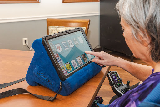 A senior individual using a tablet on a stand, highlighting the role of technology in enhancing accessibility and independence.
